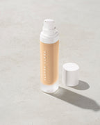 open bottle of Fenty Beauty Pro Filt'r Soft Matte Longwear Foundation with pump dispenser in shade #185 on concrete background