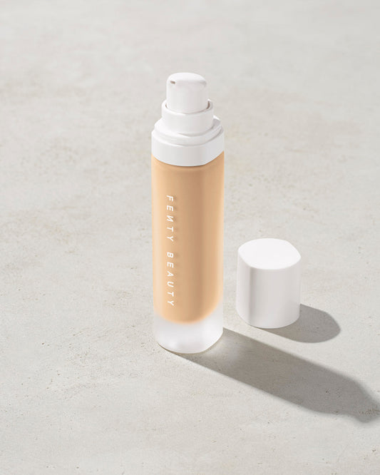 open bottle of Fenty Beauty Pro Filt'r Soft Matte Longwear Foundation with pump dispenser in shade #185 on concrete background
