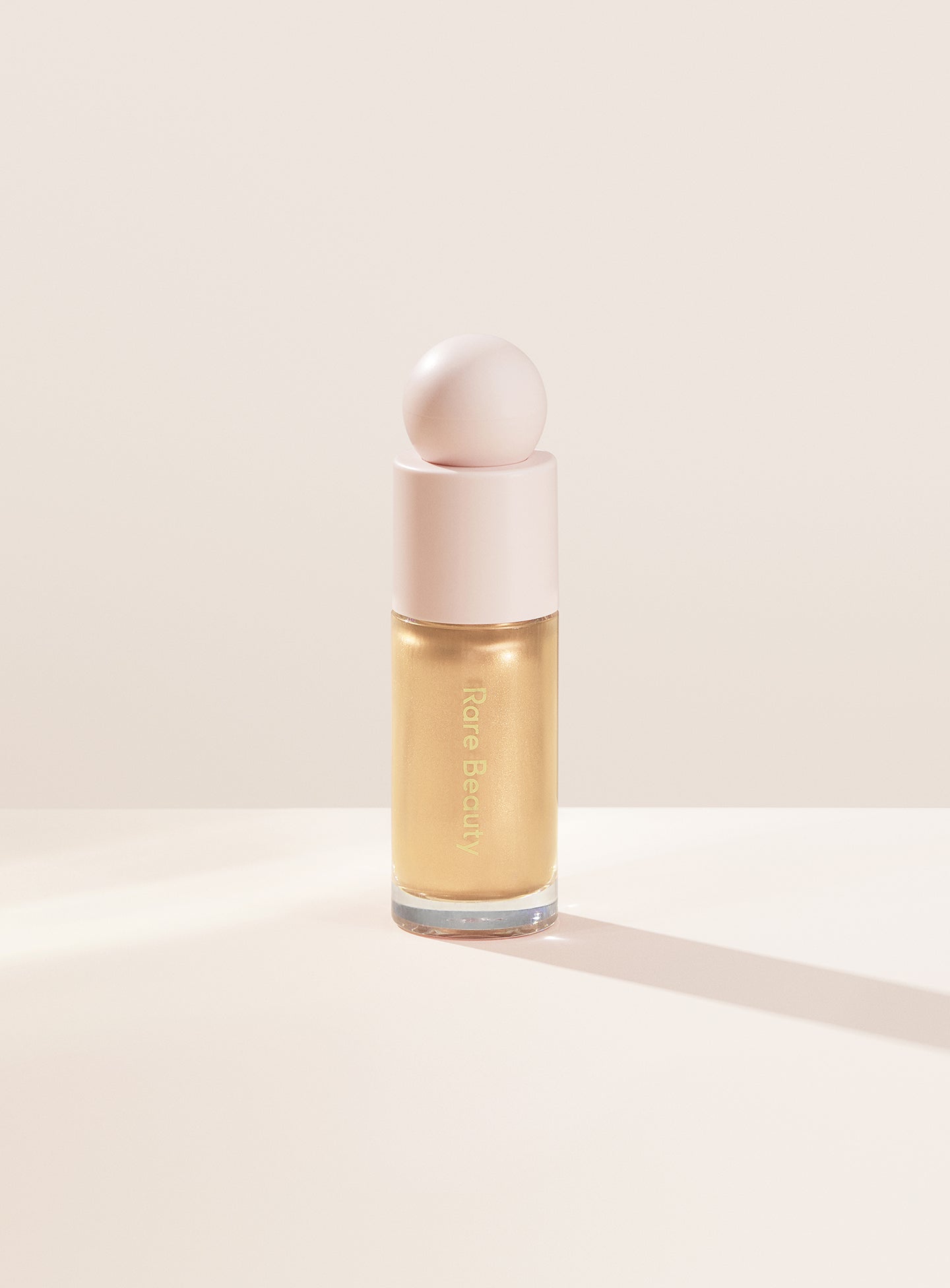 Outshine| Rare Beauty's Positive Light Liquid Luminizer in the true gold shade "Outshine."