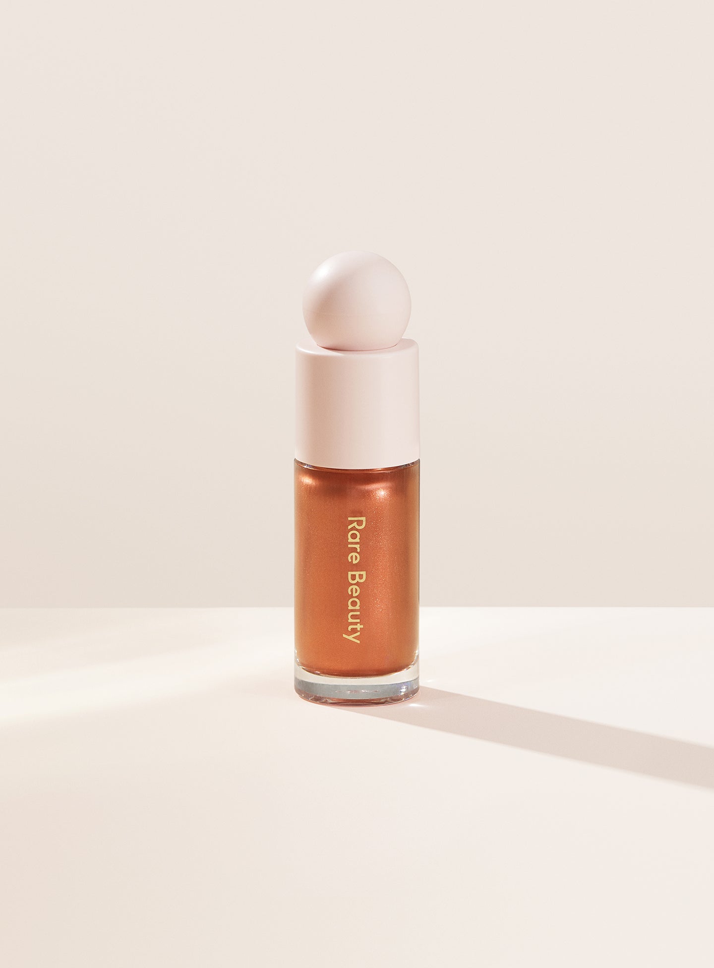 Reveal| Rare Beauty's Positive Light Liquid Luminizer in the warm copper shade "Reveal."