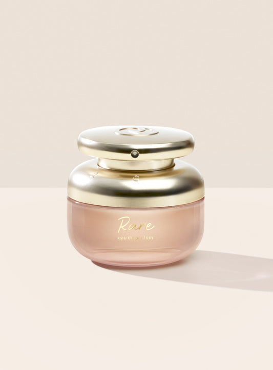 The Rare Eau de Parfum features a rounded bottle design and a gold cap with script writing.