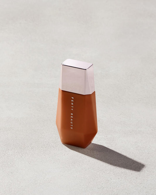 Eaze Drop’Lit All-Over Glow Enhancer shown in shade Bronze Jasper on a concrete background. 