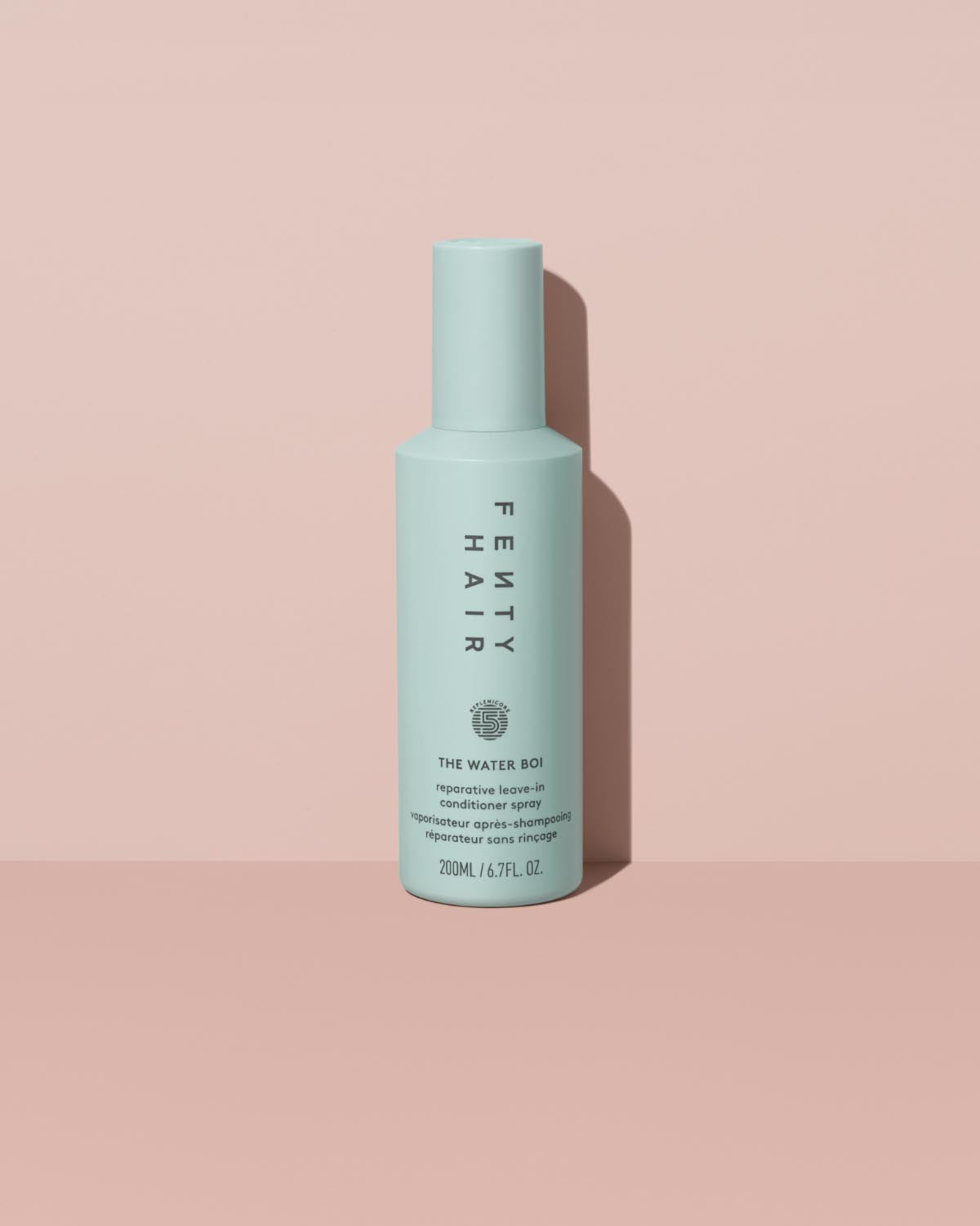 The Water Boi Reparative Leave-In Conditioner Spray on a peach background.